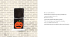 Black towel with orange pumpkin design on a brick wall background
