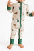 A baby wearing a long-sleeve zip-front footless sleeper in cream with green cuffs and hem, printed with small dog illustrations, photographed against a plain white background.