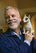 Man holding a small dog statue in a room with a blurred background