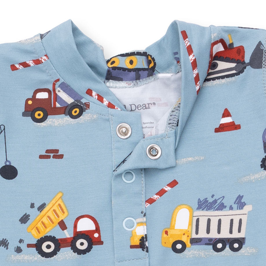 Children's shirt with construction vehicle pattern on a light blue background