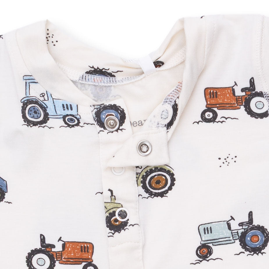 Baby onesie with tractor pattern on a white background