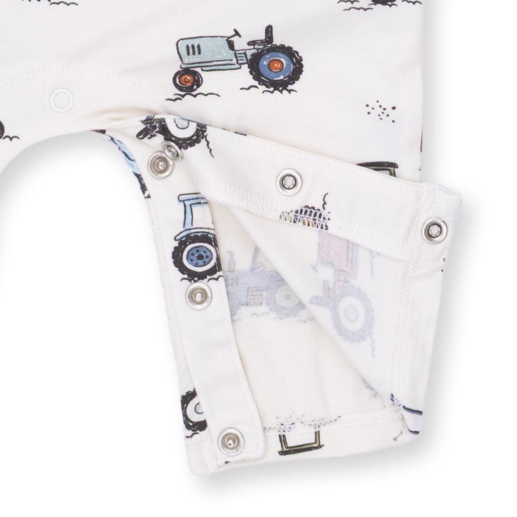Baby romper with tractor design on a white background