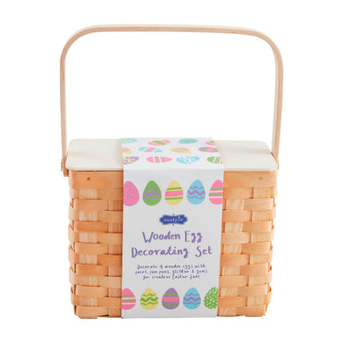 Wicker basket with a decorative label for a wooden egg decorating set on a white background