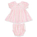 Pink baby dress with ruffled details and matching bloomers on a white background