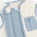 A close-up of a children's zip-front vest with a soft cream sherpa lining and light blue fabric exterior. A front pocket with a matching zipper is visible.