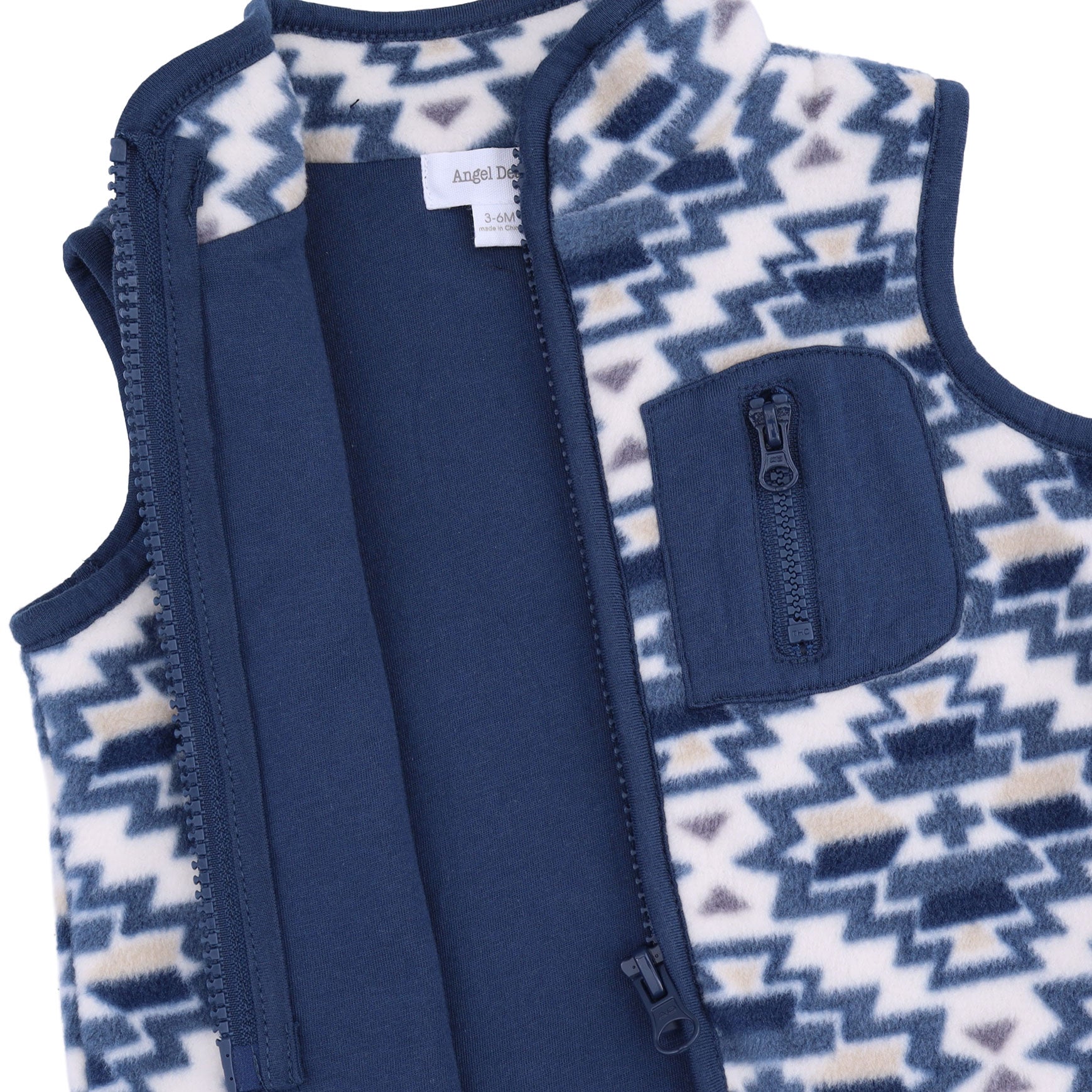 A close-up of a children's fleece vest with a navy blue zipper, solid navy inner panel, and a geometric patterned exterior in cream, navy, and light blue.