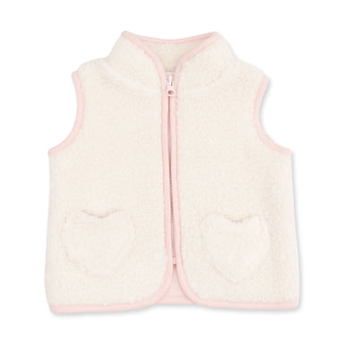 A cream-colored sherpa fleece vest with light pink trim, featuring a front zipper and two heart-shaped pockets on the front.