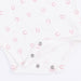 Close-up of a textured white fabric with pink horseshoe pattern and metal snaps at the crotch.