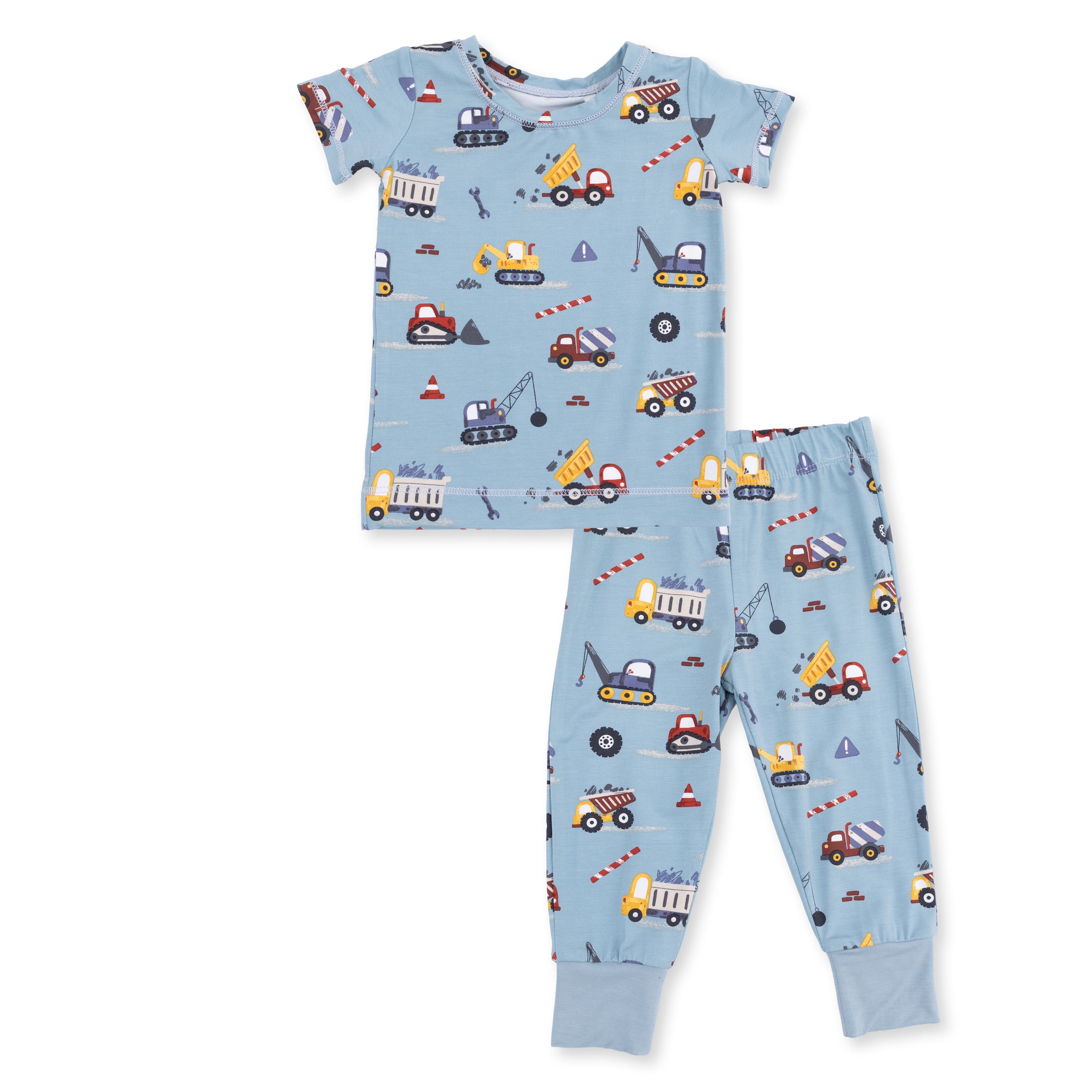 Children's pajama set with construction vehicle pattern on a light blue background