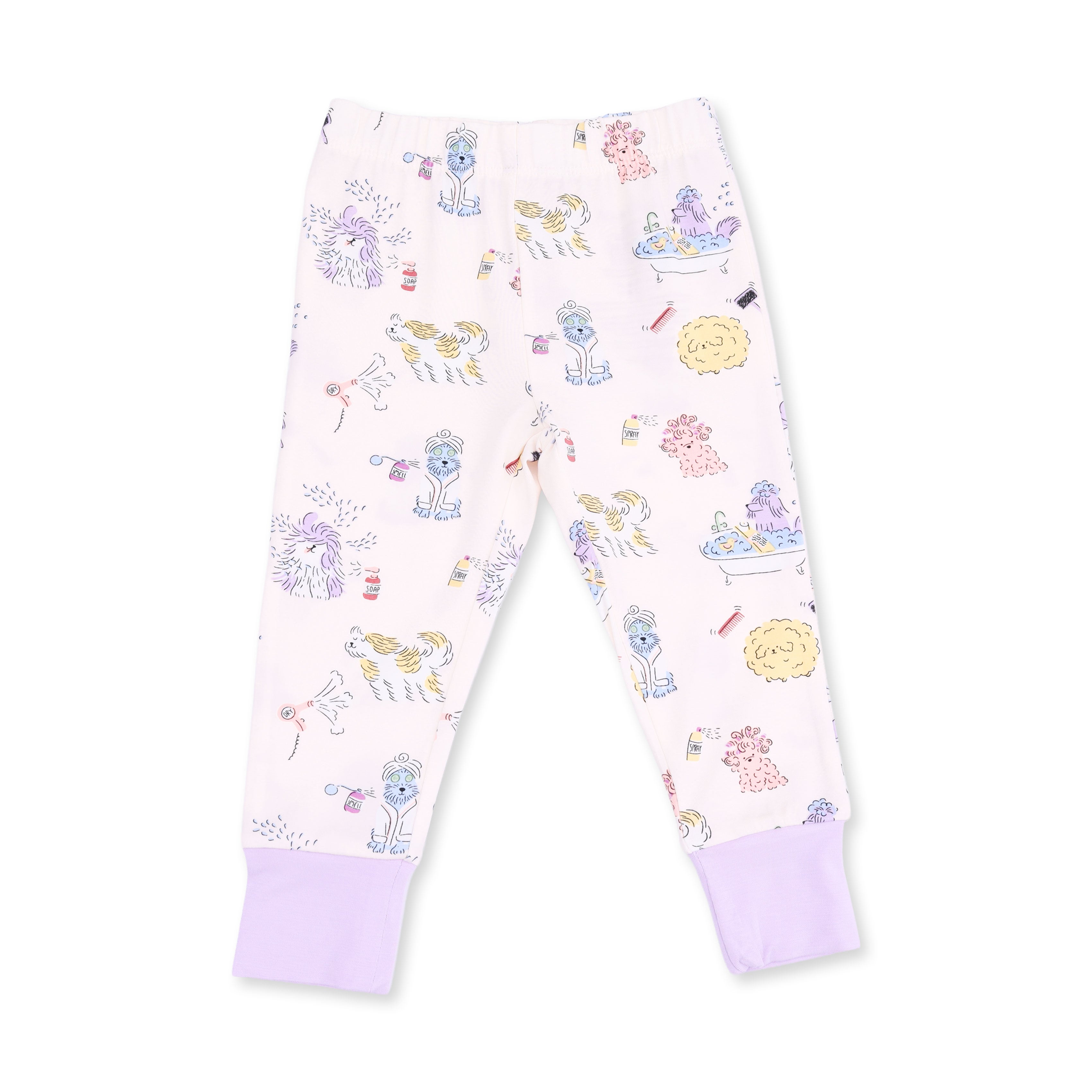 A pair of children's pajama pants in a very pale pink, featuring an allover whimsical print of cartoon dogs at the spa in pastel purple, yellow, and blue. The pants have solid light purple ribbed ankle cuffs.