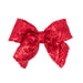 Red sequin hair bow with long tails by Wee Ones for festive holiday outfits and Christmas celebrations on a white background