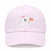A light pink and white vertically striped baseball cap featuring an embroidered white ghost with a pink bow and a small orange flag on the front.