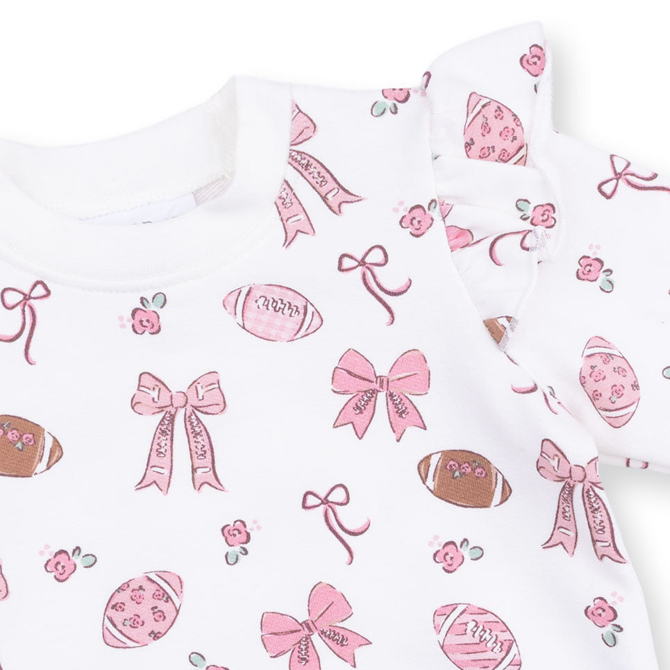 Baby onesie with pink bows and footballs on a white background