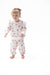 A toddler girl wearing a matching long-sleeve two piece set with a white background and a pinkish-brown football and bow print, standing against a seamless white studio background.