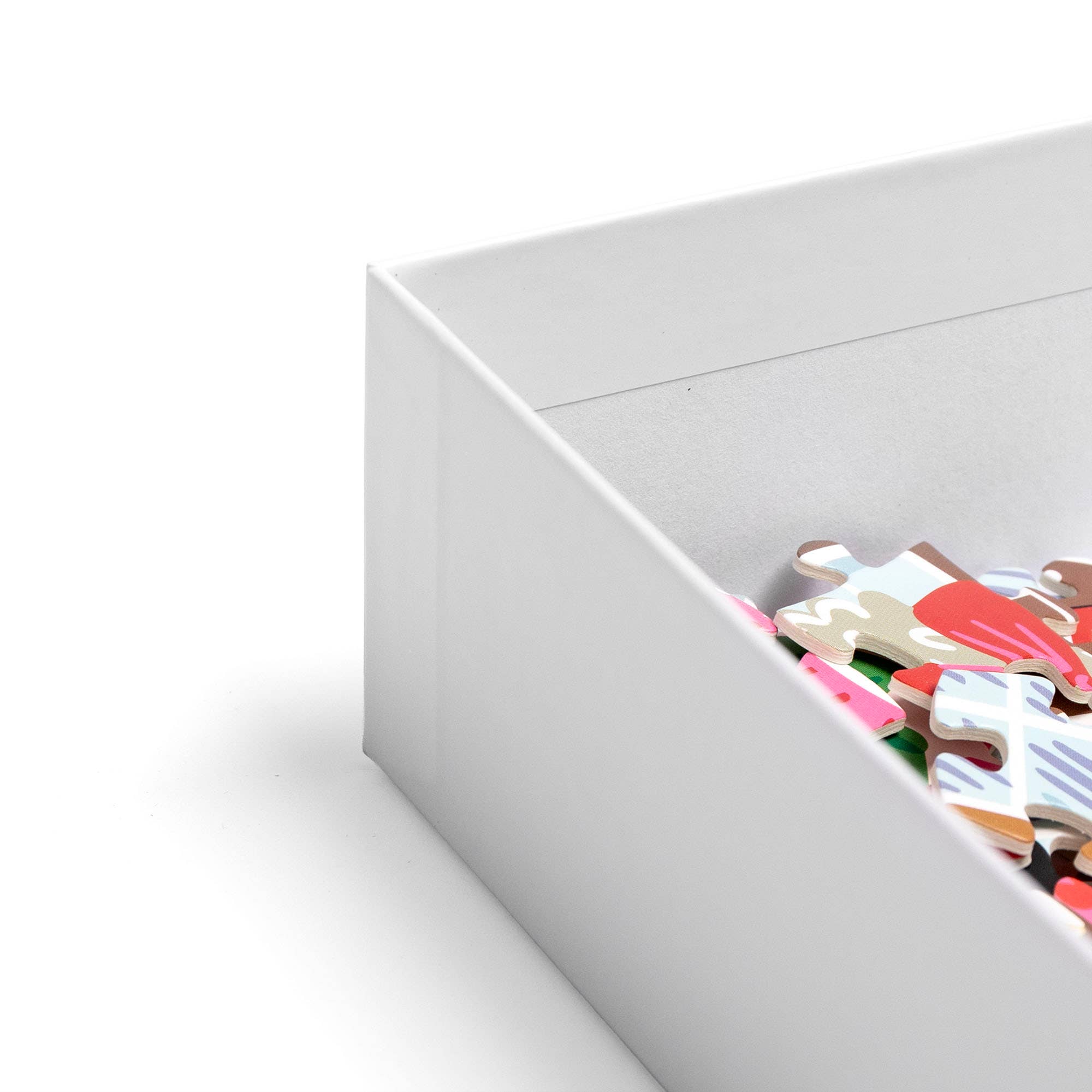 Open white jigsaw puzzle box with colorful pieces visible inside from the Pippi Post Gingerbread Square Christmas puzzle