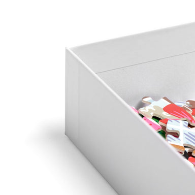 Open white jigsaw puzzle box with colorful pieces visible inside from the Pippi Post Gingerbread Square Christmas puzzle