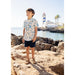 boy wearing white short sleeve collared button down with blue seashell and fish print with navy shorts