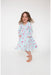 girl twirling in long sleeve blue twirl dress with pink fancy cowgirl print with hands in pockets