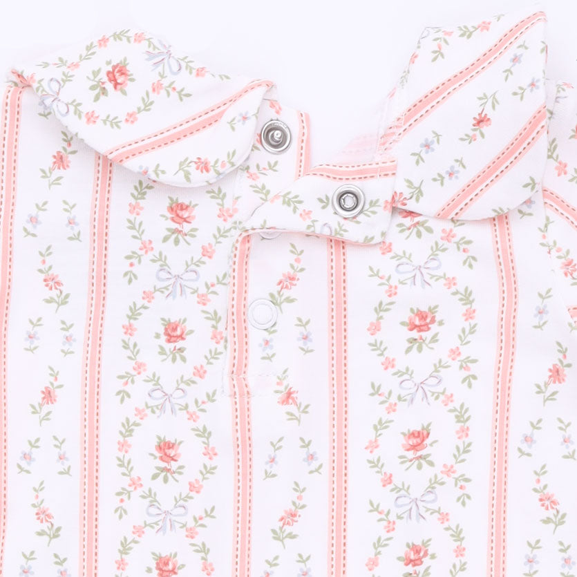 Close-up of a baby outfit featuring a white base with vertical pink stripes and a delicate pink, green, and lavender floral print.