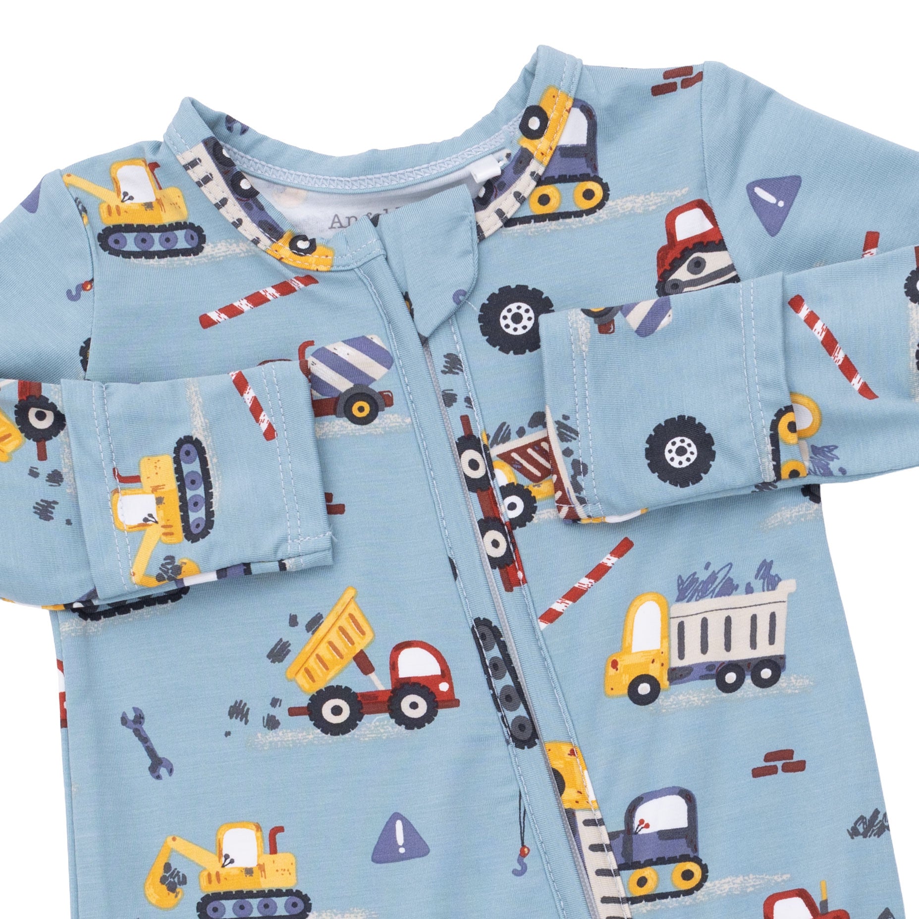 Children's pajama set with construction vehicle pattern on a light blue background