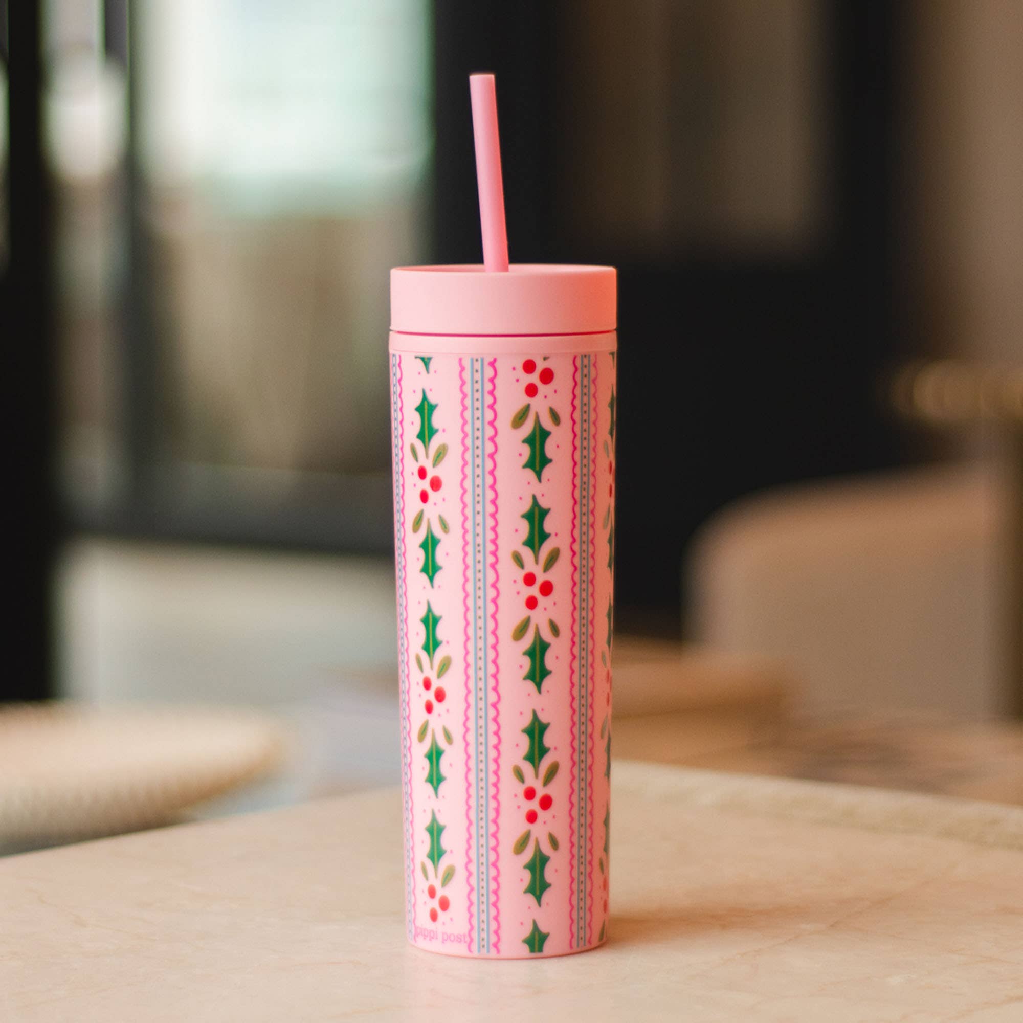 Pink Pippi Post 16 ounce acrylic tumbler with straw featuring festive holly leaves red berries and scalloped stripe patterns on a cheerful holiday design