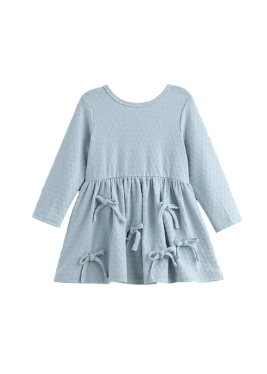 A light blue long-sleeve baby dress with a textured waffle fabric, featuring a gathered waist and four matching fabric bow details on the skirt, shown against a plain white background.