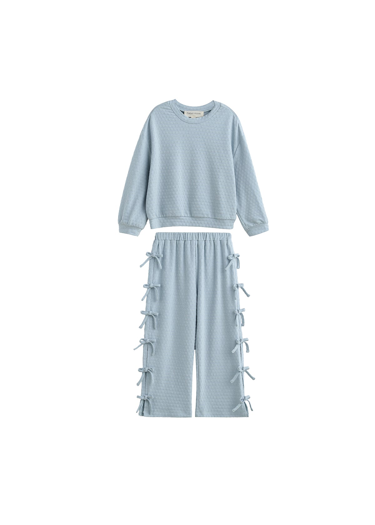 A two-piece children's lounge set in a light icy blue color, featuring a textured long-sleeve sweatshirt and matching wide-leg pants with lace-up details down the sides, shown against a plain white background.