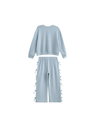 A light blue two-piece knit set featuring a cropped long-sleeve top and matching wide-leg pants with side tie details, displayed on a solid white background.