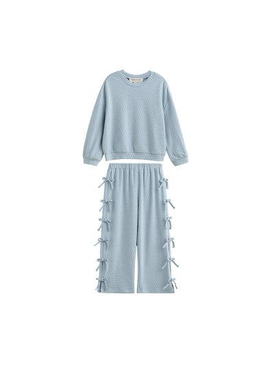 A two-piece children's lounge set in a light icy blue color, featuring a textured long-sleeve sweatshirt and matching wide-leg pants with lace-up details down the sides, shown against a plain white background.