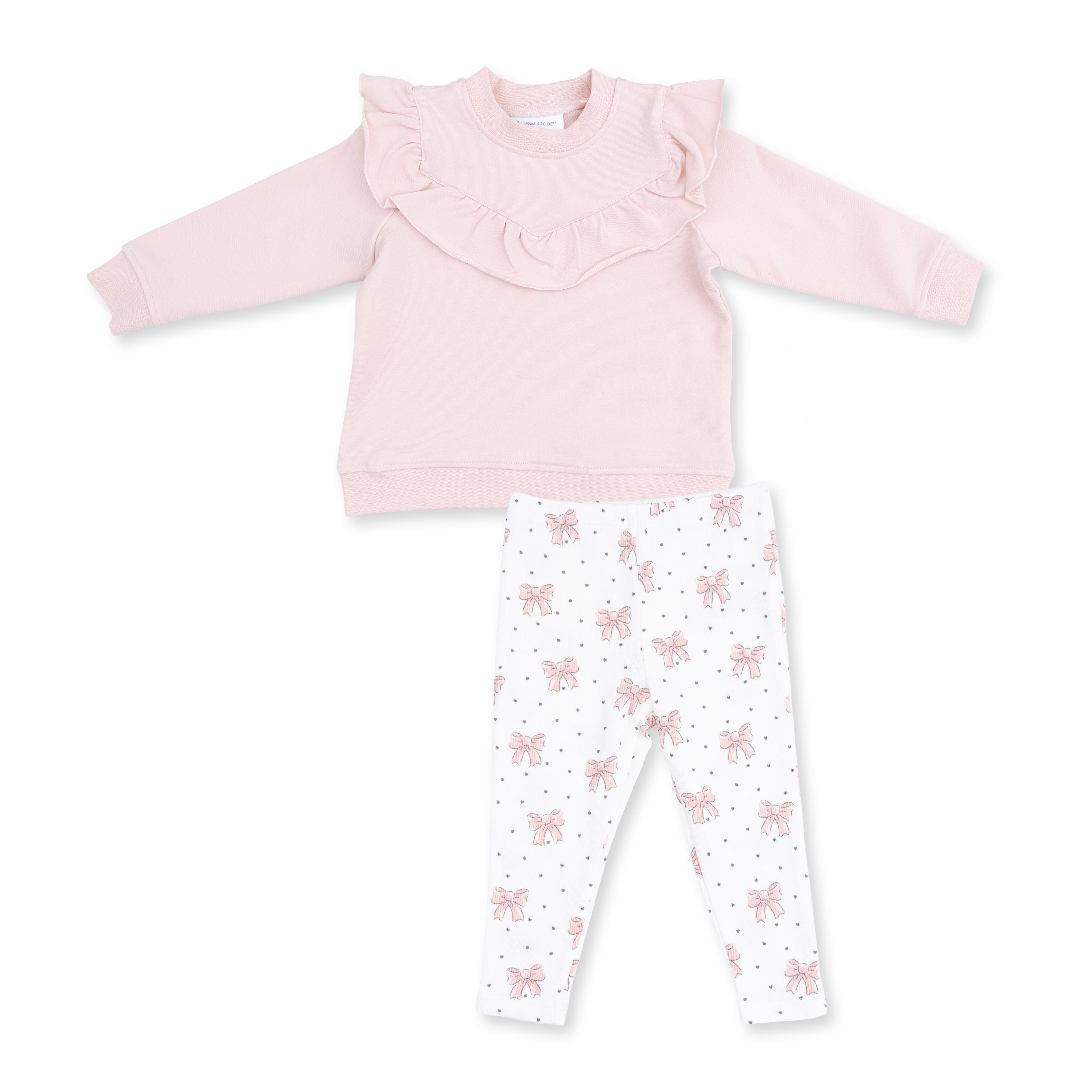 A toddler girl's two-piece clothing set featuring a light pink long-sleeve top with a ruffled collar and white leggings with a pink bow and gray polka dot pattern, laid flat on a white background.