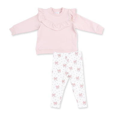 A toddler girl's two-piece clothing set featuring a light pink long-sleeve top with a ruffled collar and white leggings with a pink bow and gray polka dot pattern, laid flat on a white background.