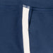 Close-up of a navy blue knit garment, likely sweatpants or a jacket, featuring a vertical white stripe running down the front.