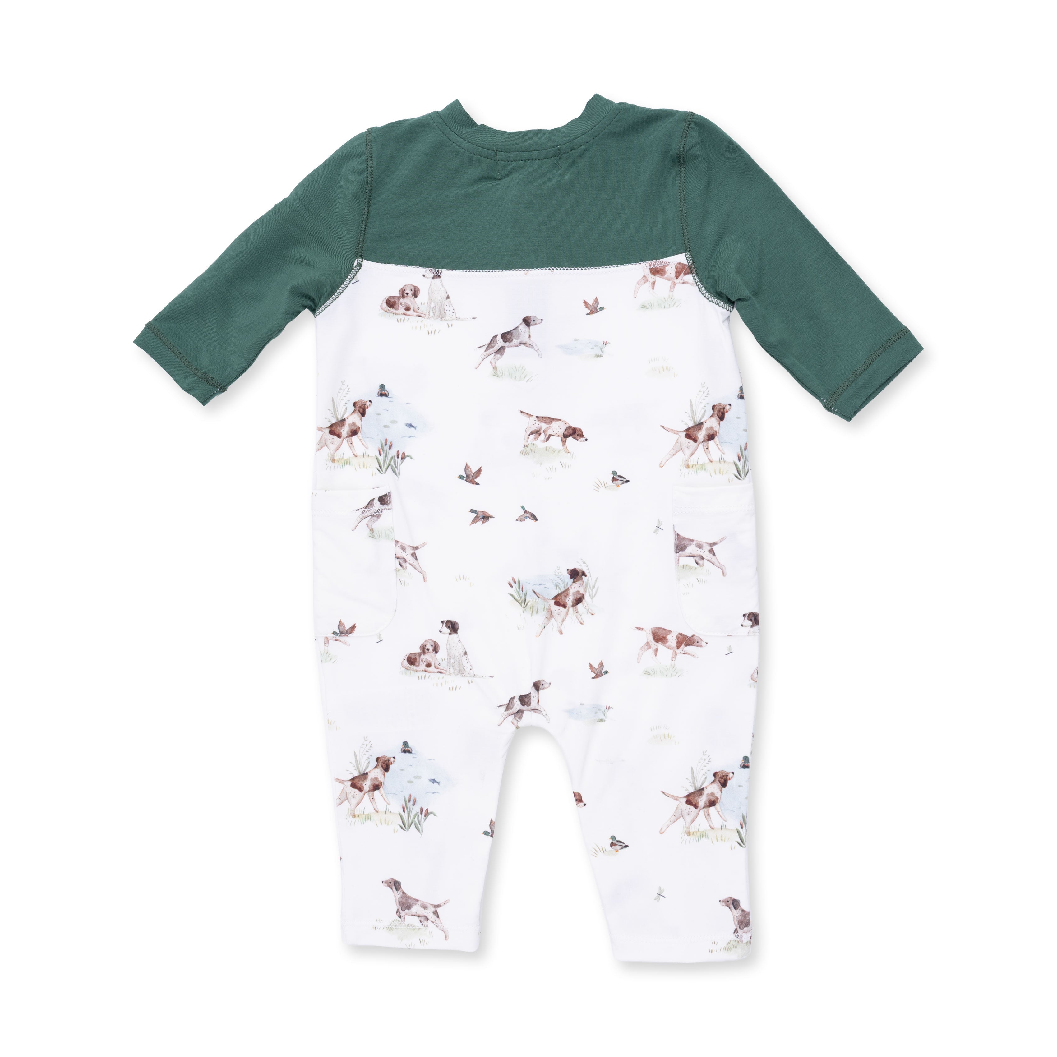 Baby romper with green long-sleeve top and dog and duck patterned white pants on a white background