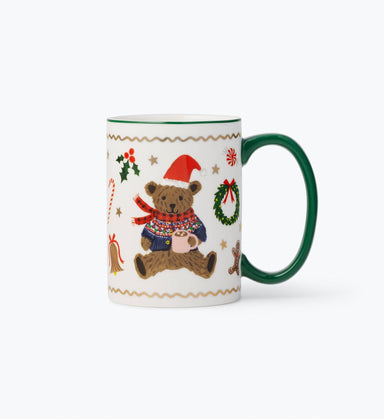 Porcelain holiday mug with green handle and rim featuring a cozy bear in a Santa hat scarf and sweater inspired illustrations by Rifle Paper Co.