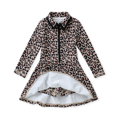 A long-sleeve collared tennis dress with a leopard print pattern in beige, brown, and black, featuring a black front zipper and a white inner lining visible at the split hem, with built-in shorts.