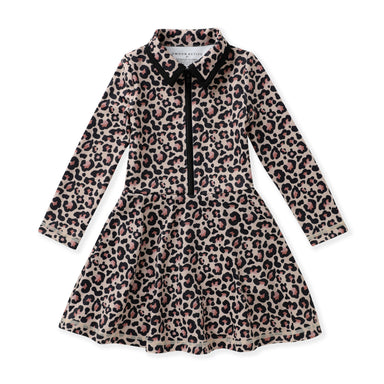 A long-sleeve girl's tennis dress with a leopard print pattern in beige, brown, and black, featuring a black collar, black tie detail at the neckline, and a black front zipper.