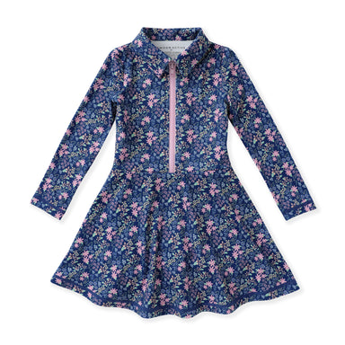 A girls' long-sleeve tennis dress with a navy blue floral print, featuring a pink zipper at the collar and a flared skirt, shown flat on a white background.