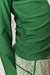 Close-up of a green long-sleeve ruched top paired with green floral-patterned bottoms, cropped to show the torso and waist area.
