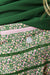 Close-up of a green floral-patterned fabric with a pink zipper pocket and a small white circular logo, alongside a solid dark green section.