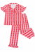 A two-piece womens' pajama set featuring a short-sleeve button-up top and matching pants. The fabric has a red and pink vertical stripe pattern with small white sailboats printed repeatedly.