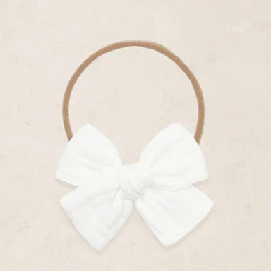 White bow headband on a beige background