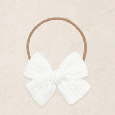White bow headband on a beige background