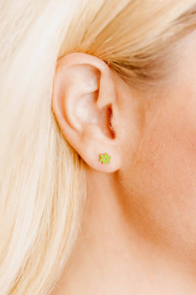 Close-up of a person wearing a green flower earring.