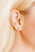 Close-up of a person wearing a green flower earring.