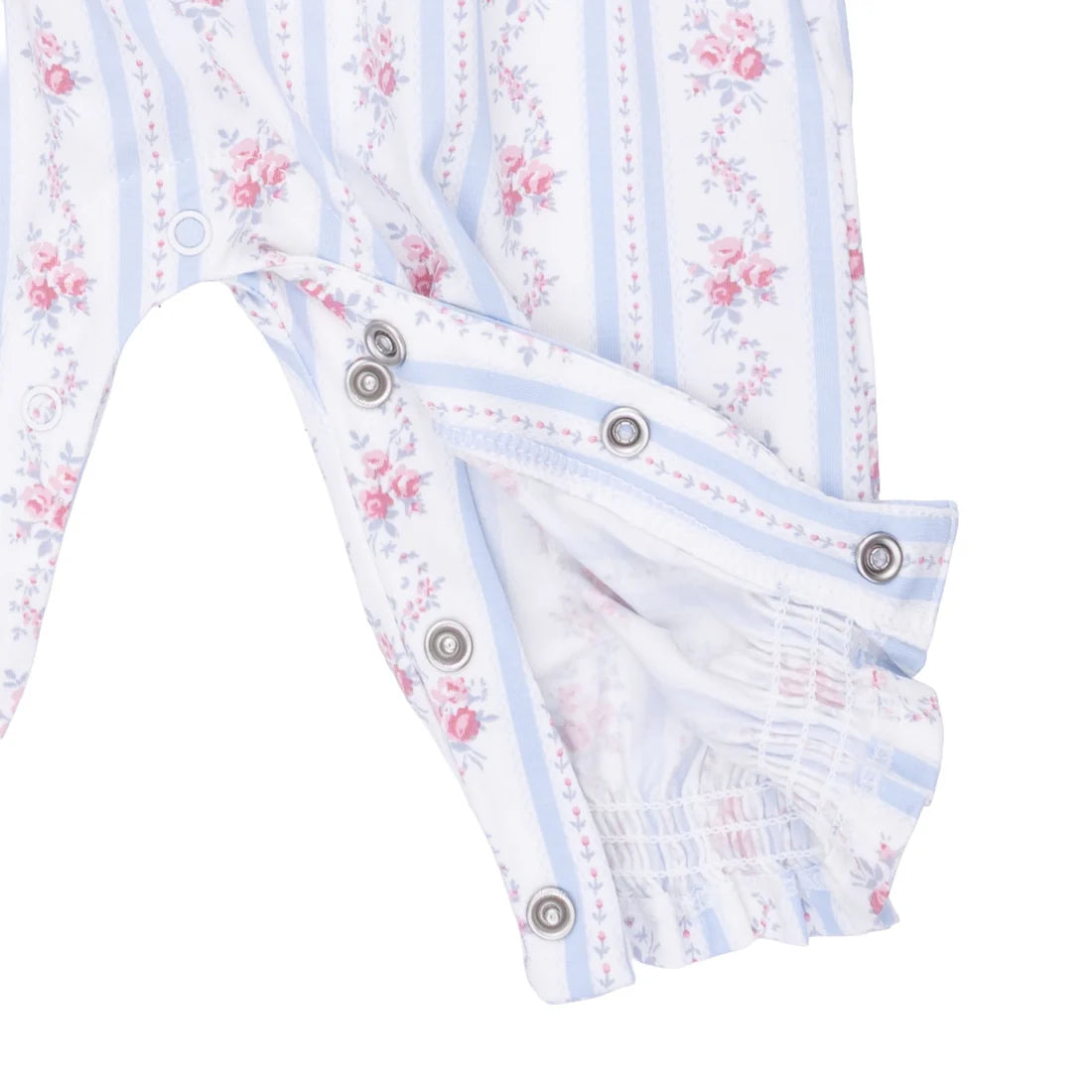 Close-up of a baby garment with a white base, light blue vertical stripes, and a pink floral print. The fabric shows snap-button closures and an elasticized ruffled hem.