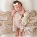 Newborn baby in a pink outfit with a knitted bunny toy and 'hello world' sign on a floral blanket.