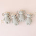 Four knitted elephant toys with flower crowns on a pink background