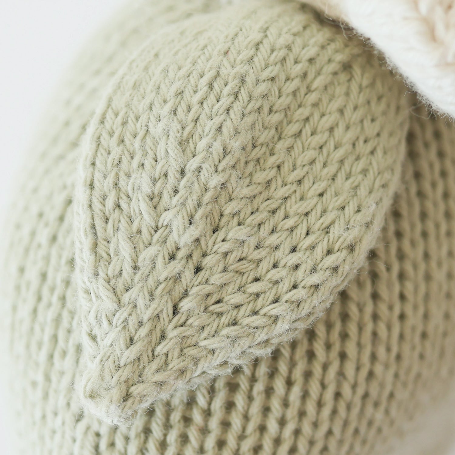 Close-up of a knitted fabric with a textured pattern on a light background