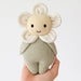 Knitted toy resembling a flower held in a hand against a light background