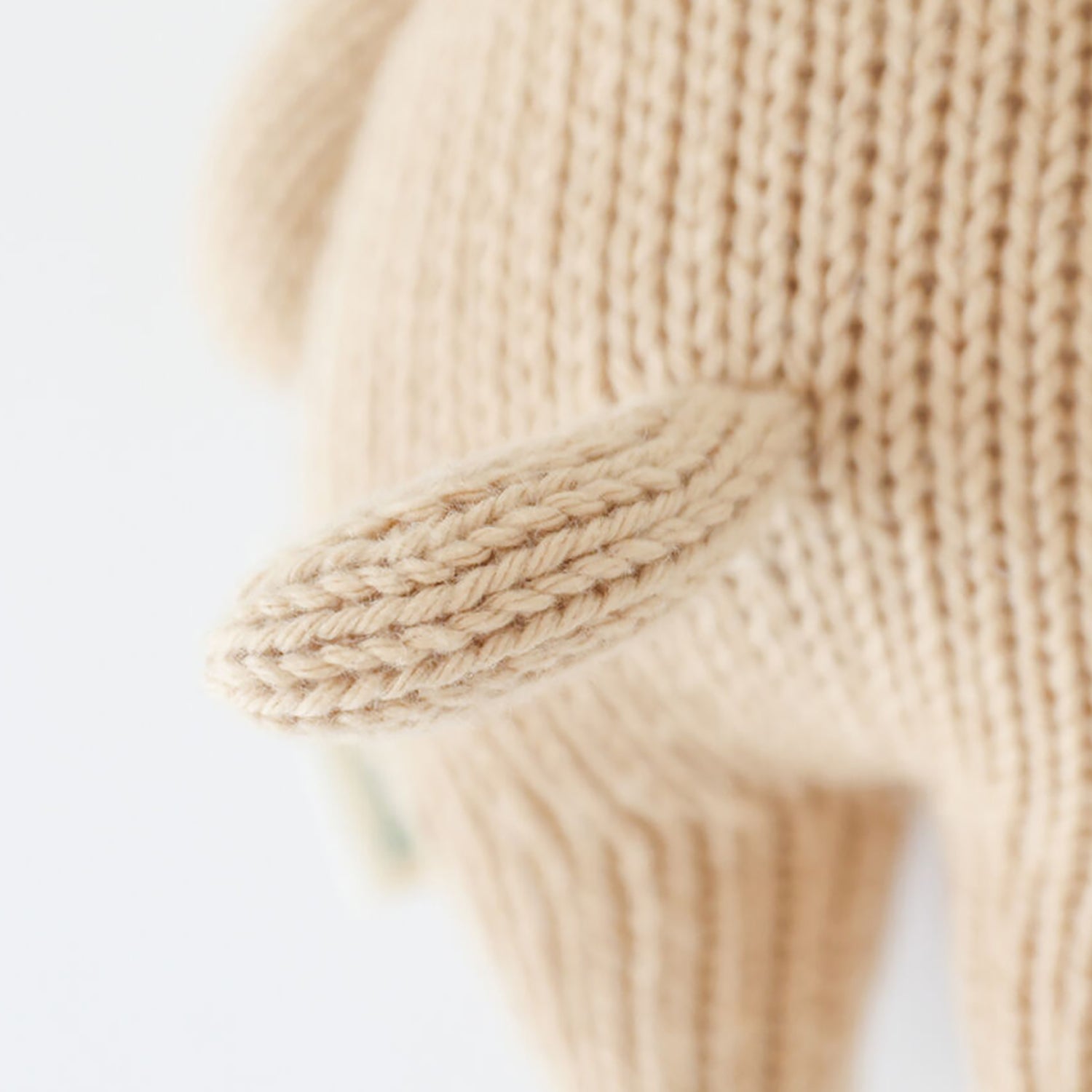 Close-up of beige knitted gloves on a light background